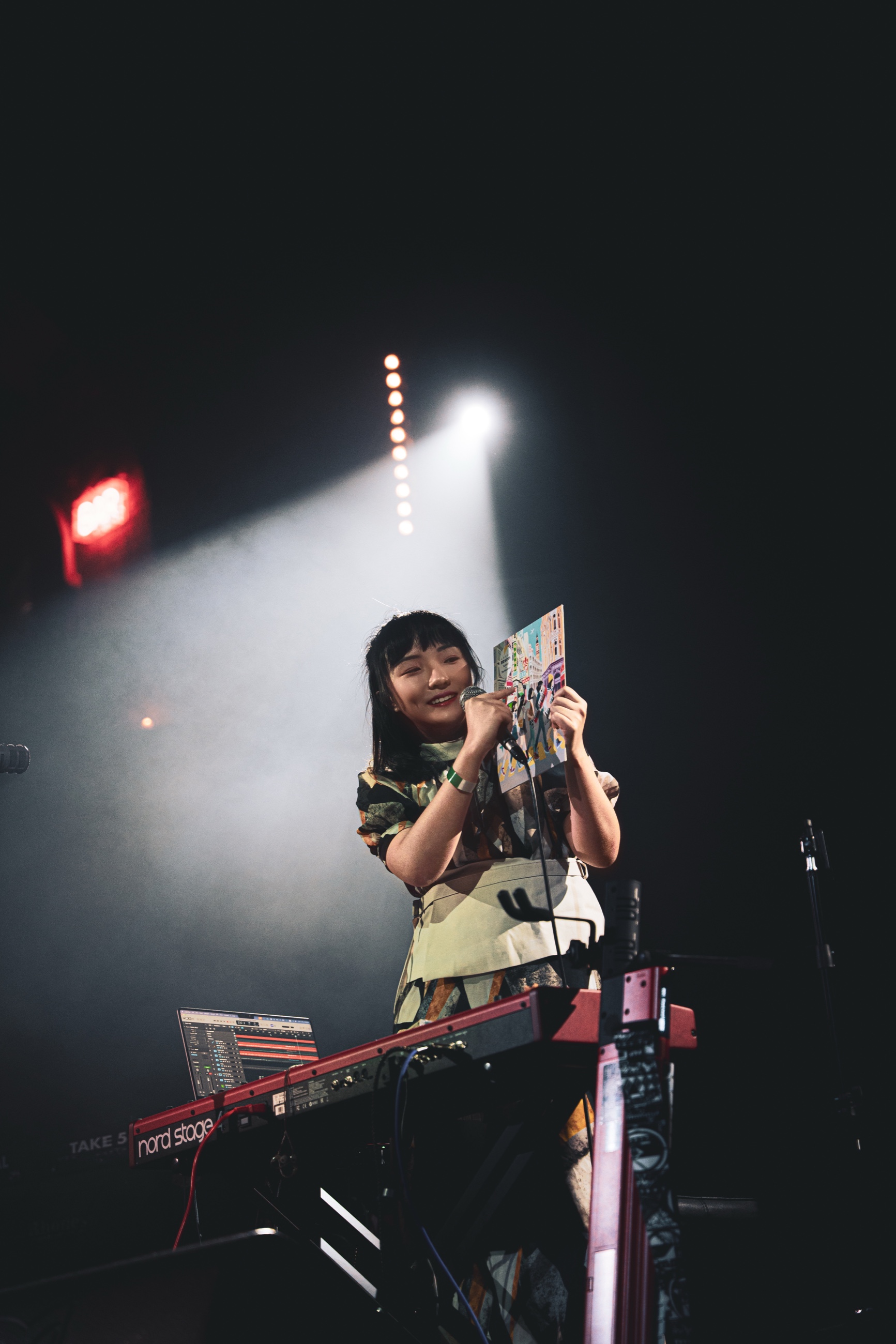 TC.KYLIE holding the RE:birth artwork on stage at Union Chapel