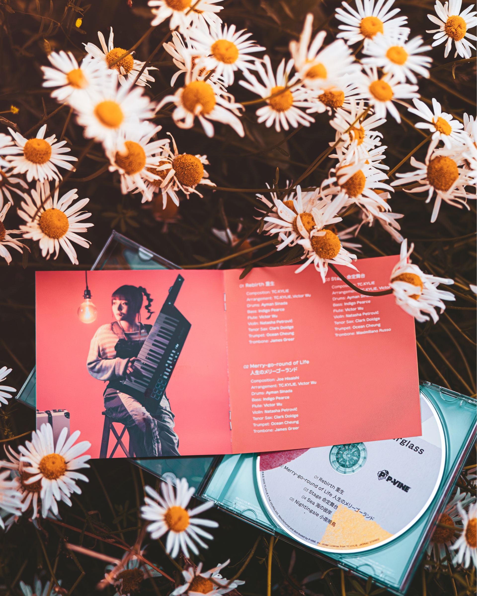 RE:birth credits booklet, portrait and disc among flowers