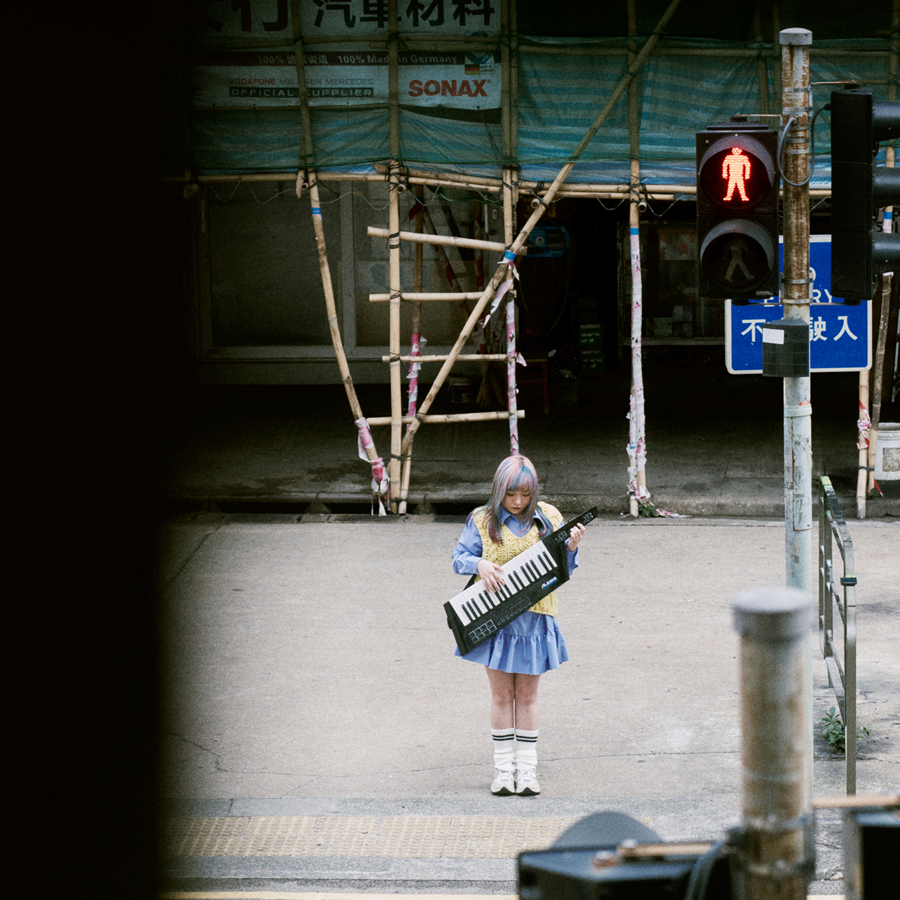 Kylie and her keytar beside a Hong Kong pedestrian crossing